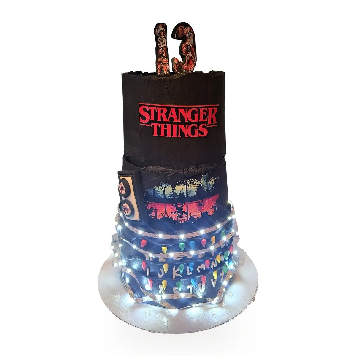 Gâteau d'anniversaire 3 étages thème Stranger Things avec guirlande lumineuse, cake design Seine-Saint-Denis